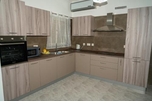 a kitchen with white cabinets and a microwave at Sea-View Studio Apartment - Sleeps 2 in Marsaskala