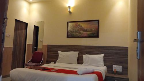 a hotel room with a bed and a chair at Terminus Square in Kurla