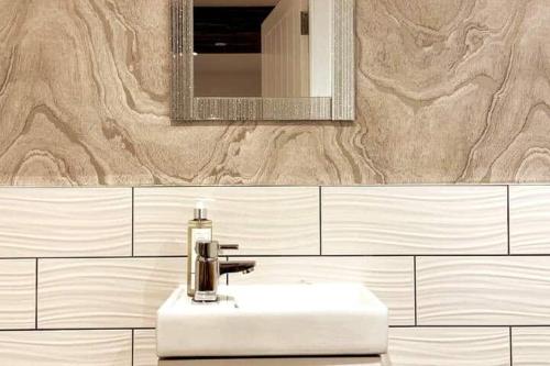 ein Badezimmer mit einem weißen Waschbecken und einem Spiegel in der Unterkunft LOVELY 3 BEDROOM APARTMENT WITH PRIVATE GARDEN IN EDINBURGH CITY CENTRE in Edinburgh