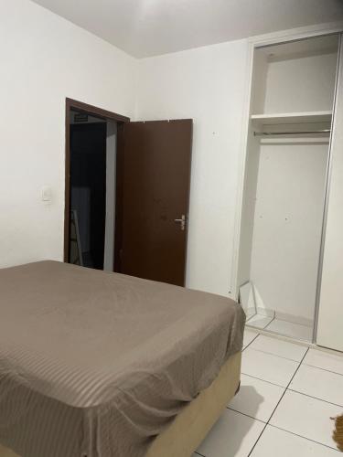 um quarto com uma cama, um armário e uma porta em Quarto em frente moradia unicamp em Campinas