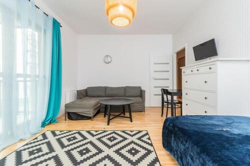 a living room with a couch and a table at Zajezdnia Wrzeszcz by Grand Apartments in Gdańsk