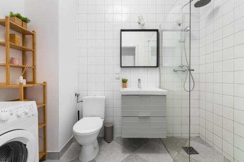 a bathroom with a toilet and a sink and a shower at Zajezdnia Wrzeszcz by Grand Apartments in Gdańsk