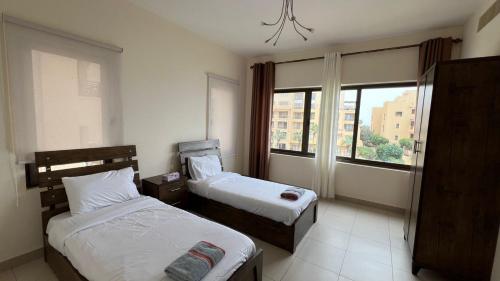 E25 Samarah Resort Apartments في السويمة: غرفة فندقية بسريرين ونافذة