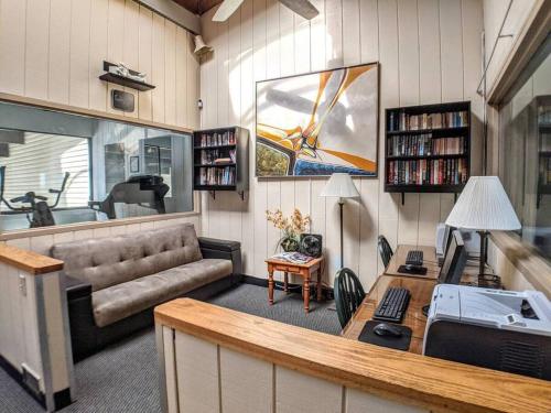 a living room with a couch and a table at Cute Lower Level Cedar Lodge Room with Balcony & Lake Views! in Laconia