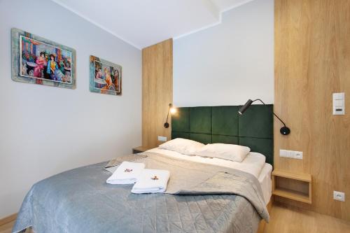 1 dormitorio con 1 cama y 2 toallas blancas en PARK APARTAMENTY Krynica Zdrój en Krynica Zdrój
