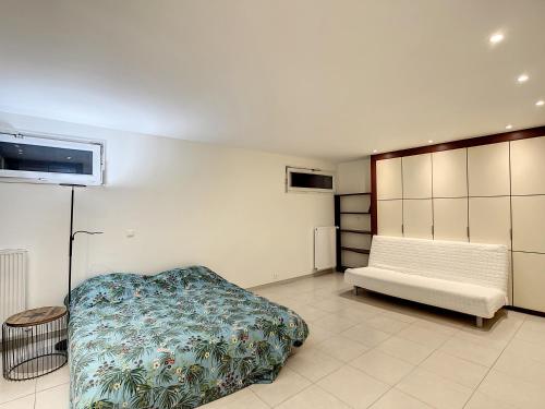 ein Schlafzimmer mit einem Bett und einer Bank darin in der Unterkunft Chambre d’hôtes Stéphane in Puteaux