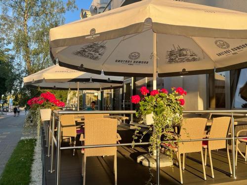 una cafetería al aire libre con mesas, sillas y sombrillas en Koral Świnoujście, en Świnoujście