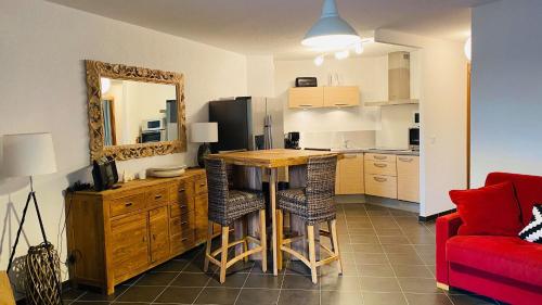 une cuisine avec une table et un canapé rouge dans l'établissement Appartement Punta Rossa Calvi, à Calvi