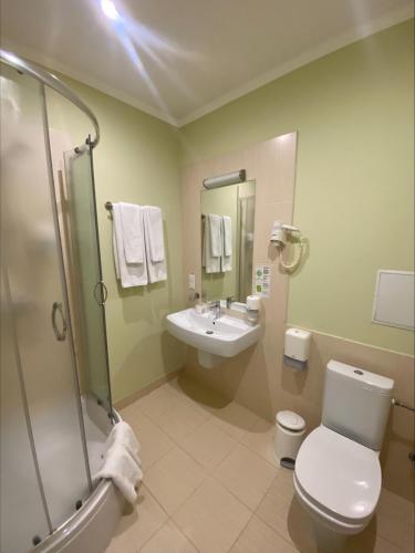 a bathroom with a toilet and a sink and a shower at Optima Vinnytsia in Vinnytsya