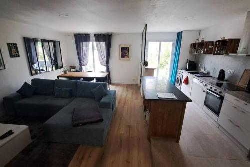 ein Wohnzimmer mit einem Sofa und einer Küche in der Unterkunft Location de charme in Le Haillan