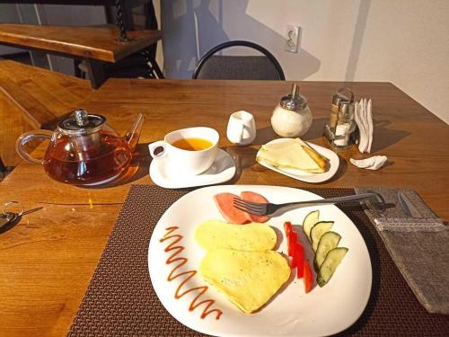 a table with a plate of food and a cup of tea at SEQUOIA boutique hotel in Taraz