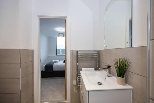 a bathroom with a sink and a bedroom at Pass the Keys Modern apartment - with parking in Manchester