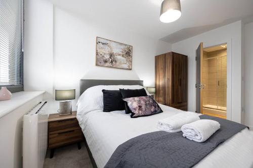 1 dormitorio con 1 cama blanca grande y 2 almohadas en Pass the Keys Modern apartment - with parking en Mánchester