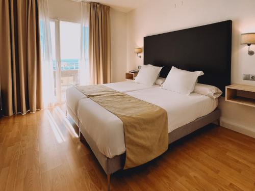 ein Schlafzimmer mit einem großen Bett und einem großen Fenster in der Unterkunft Fay Victoria Beach in Rincón de la Victoria