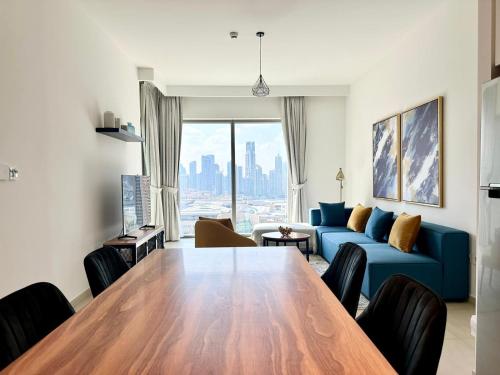 uma sala de estar com uma mesa e um sofá azul em Luxury Apartment Downtown Dubai Mall Burj Khalifa View free Netflix & Prime Video em Dubai