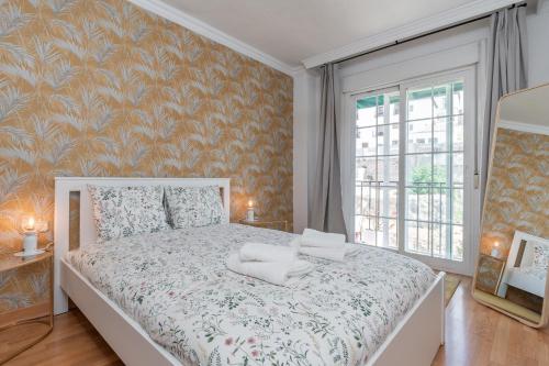 a bedroom with a bed with a floral wallpaper at tuGuest San Agustin II Apartment in Granada