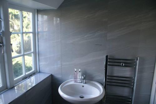 a white bathroom with a sink and a window at Inviting Relaxing 2-Bed House-Hampstead-London in London