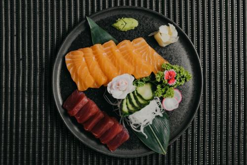 a plate of sushi and vegetables on a table at Mare Hotel in Dos Hermanas