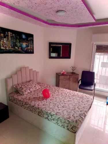 ein Schlafzimmer mit einem Bett mit einem roten Ball drauf in der Unterkunft Falcon homes in Amman
