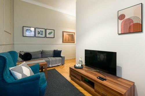 a living room with a couch and a flat screen tv at WAWELOVE ROYAL spacious 2 bedroom apt 1 min to Main Sq! in Krakow