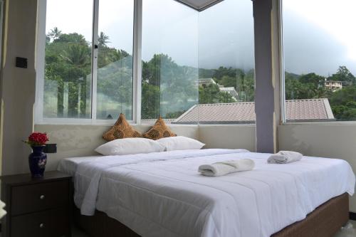a bedroom with a white bed with a large window at Eye Catch Kandy in Kandy