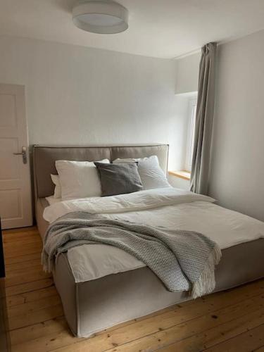 a bedroom with a large bed with white sheets and pillows at Mosel-Charm - Urige Dachgeschosswohnung - 3 Schlafzimmer für 6 Personen - Liebevoll renoviert & gemütlich in Ürzig