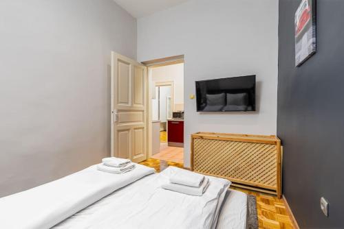 a bedroom with a bed and a flat screen tv at Bold Base Apartment in Budapest