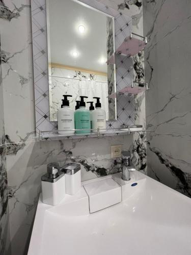 uma casa de banho com um lavatório branco e um espelho. em ЖК Riverside -к1 em Almaty