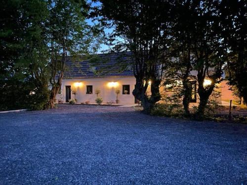 une maison blanche avec des arbres devant dans l'établissement Chambre confortable, à Saint-Amand-les-Eaux
