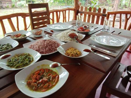 a wooden table with plates of food on it at Thought Blooming in Udawalawe