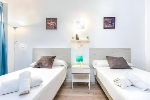 two beds in a room with white walls at Hotel Boogaloo - Adults Only in El Arenal
