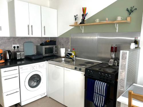 a kitchen with a washing machine and a washer at Comfortable and convenient 1-Bed Apart in Romford in Romford