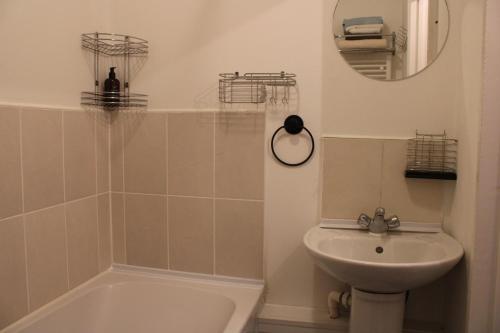 a bathroom with a sink and a toilet and a mirror at Comfortable and convenient 1-Bed Apart in Romford in Romford