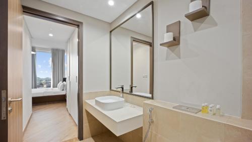 a white bathroom with a sink and a mirror at Exceptional 1 BR next to Dubai Metro and World Trade Center Dubai by GP Holiday Homes in Dubai