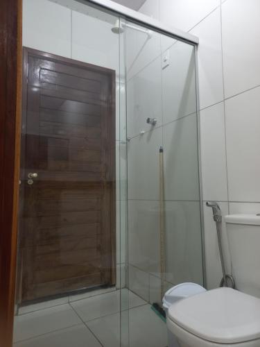 a bathroom with a glass shower with a toilet at Pousada Residencial acochego caririense in Juazeiro do Norte