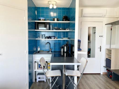 - une cuisine avec du carrelage bleu, un comptoir et des chaises dans l'établissement Red Lion, à Marseille