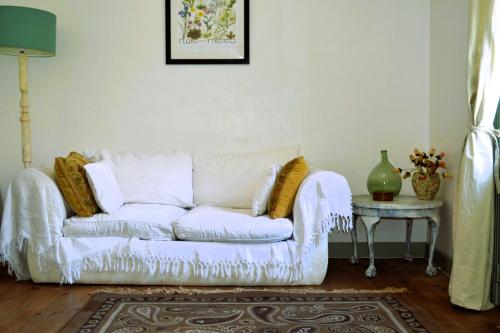 un sofá blanco en una sala de estar con mesa en Gite Esmeralda, en Biert