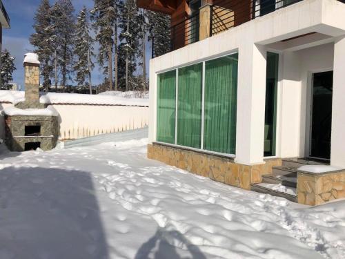 a house with snow on the ground next to a window at Bakuriani - Kokhta Gora in Bakuriani