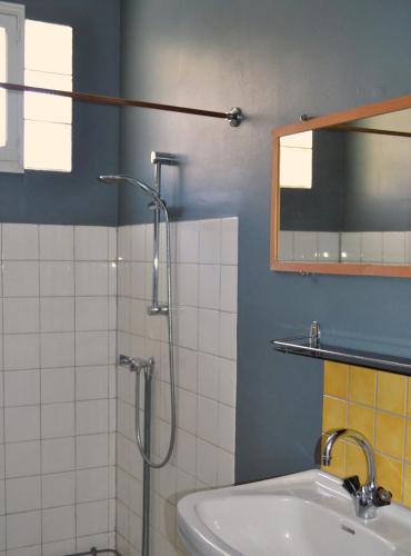 une salle de bain avec une douche, un lavabo et un miroir dans l'établissement Gite Esmeralda, à Biert