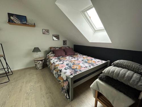 ein Schlafzimmer mit einem Bett mit einer Bettdecke und einem Fenster in der Unterkunft CHAMBRE PRIVÉE dans une maison in Argenteuil