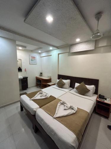 a bedroom with two beds with towels on them at Hotel The Excellency in Surat
