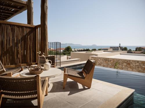 a patio with chairs and a table next to a swimming pool at Pierros Verde in Lithakia