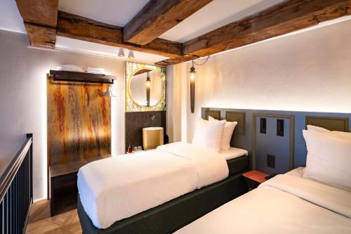 a bedroom with two beds and a mirror on the wall at Mister Highland Hotel in Amsterdam