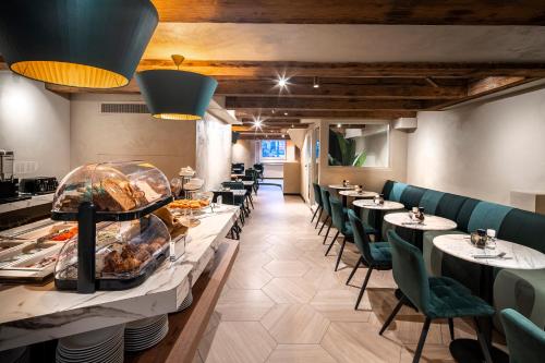 a restaurant with long tables and green chairs at Mister Highland Hotel in Amsterdam