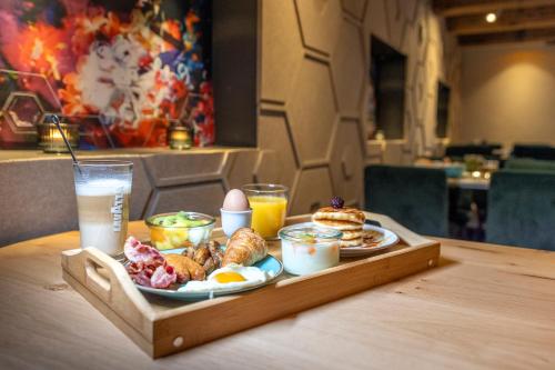 a tray of breakfast foods and drinks on a table at Mister Highland Hotel in Amsterdam