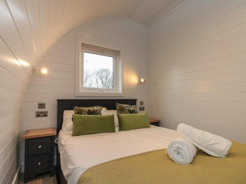 a bedroom with a large bed with a window at Lennon Lodge in Burton Fleming
