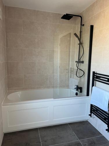 Das Bad ist mit einer Badewanne mit einer Dusche ausgestattet. in der Unterkunft Brian’s Escape in Great Driffield