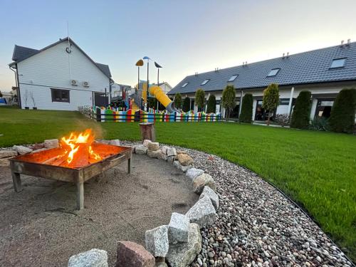 a fire pit in a yard with a playground at Amelia Resort in Sianozety