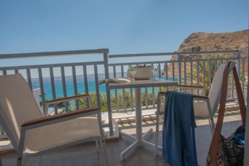 a balcony with a table and chairs and the ocean at Athina Residence in Léntas