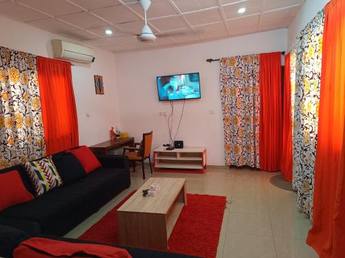 a living room with red curtains and a couch at AKD Résidence et Automobile in Ouagadougou